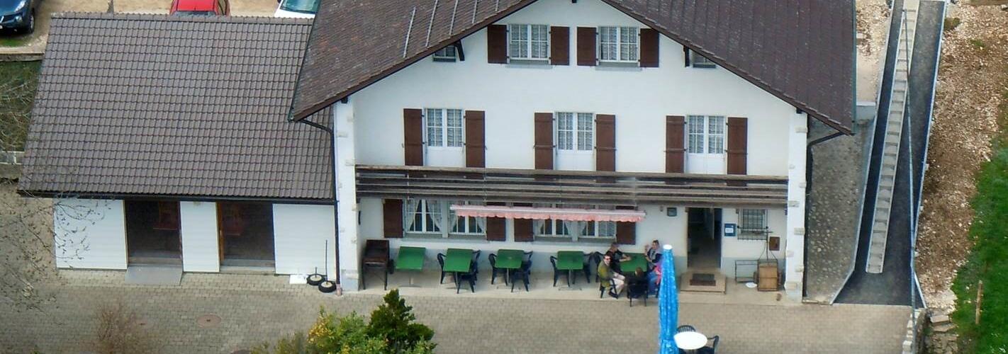 ein großes Haus mit einem großen weißen Dach und einem blauen Regenschirm