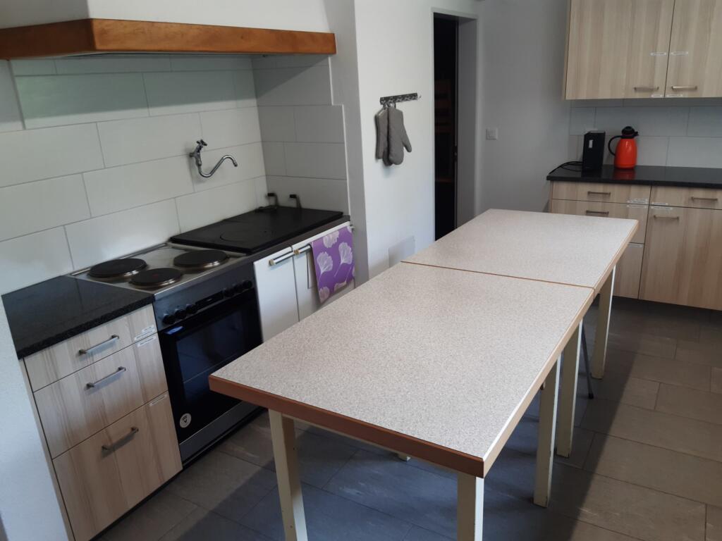 une cuisine avec une longue table et une cuisinière 