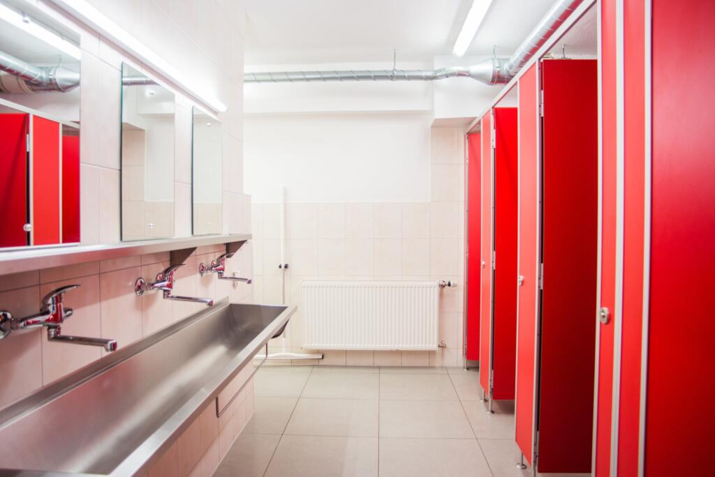 une salle de bains avec un lavabo, des toilettes et des cabines 