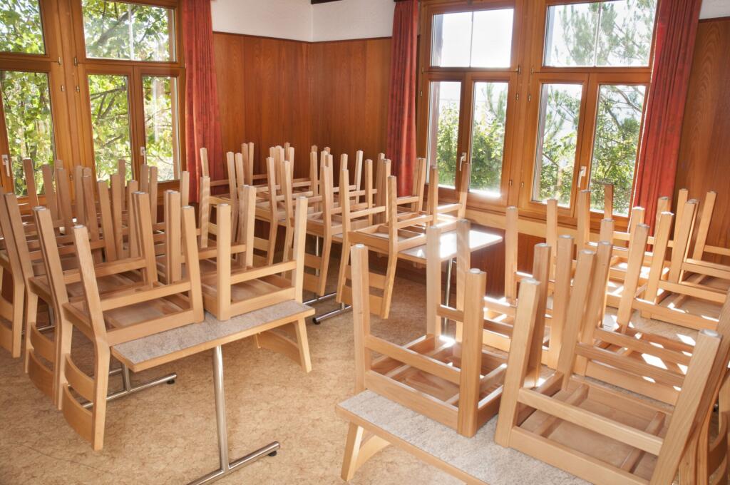 une salle avec de nombreuses chaises et tables 