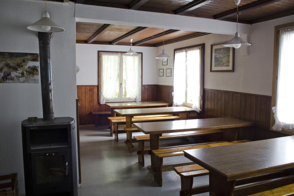 une salle avec des tables et des bancs en bois 