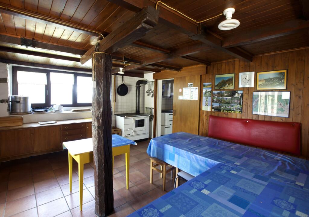 une cuisine avec une table et des chaises et une cuisinière 